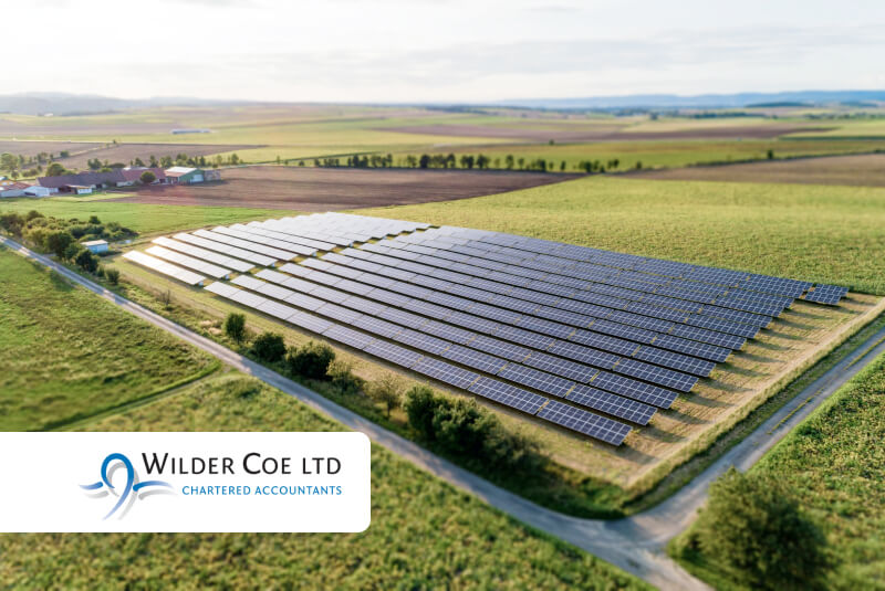 Wilder Coe's logo overlaid onto a photo of a solar energy farm