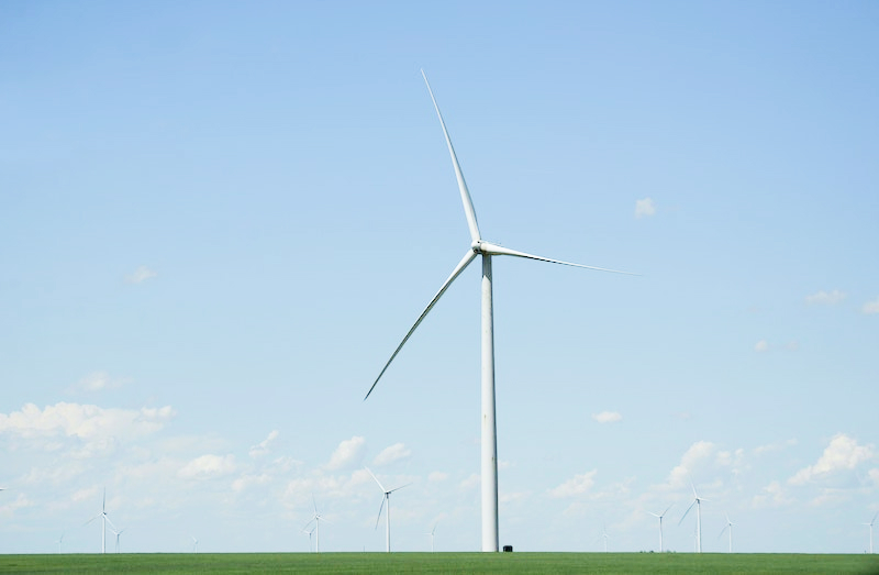 Photo of a windfarm with one windmill front and center.